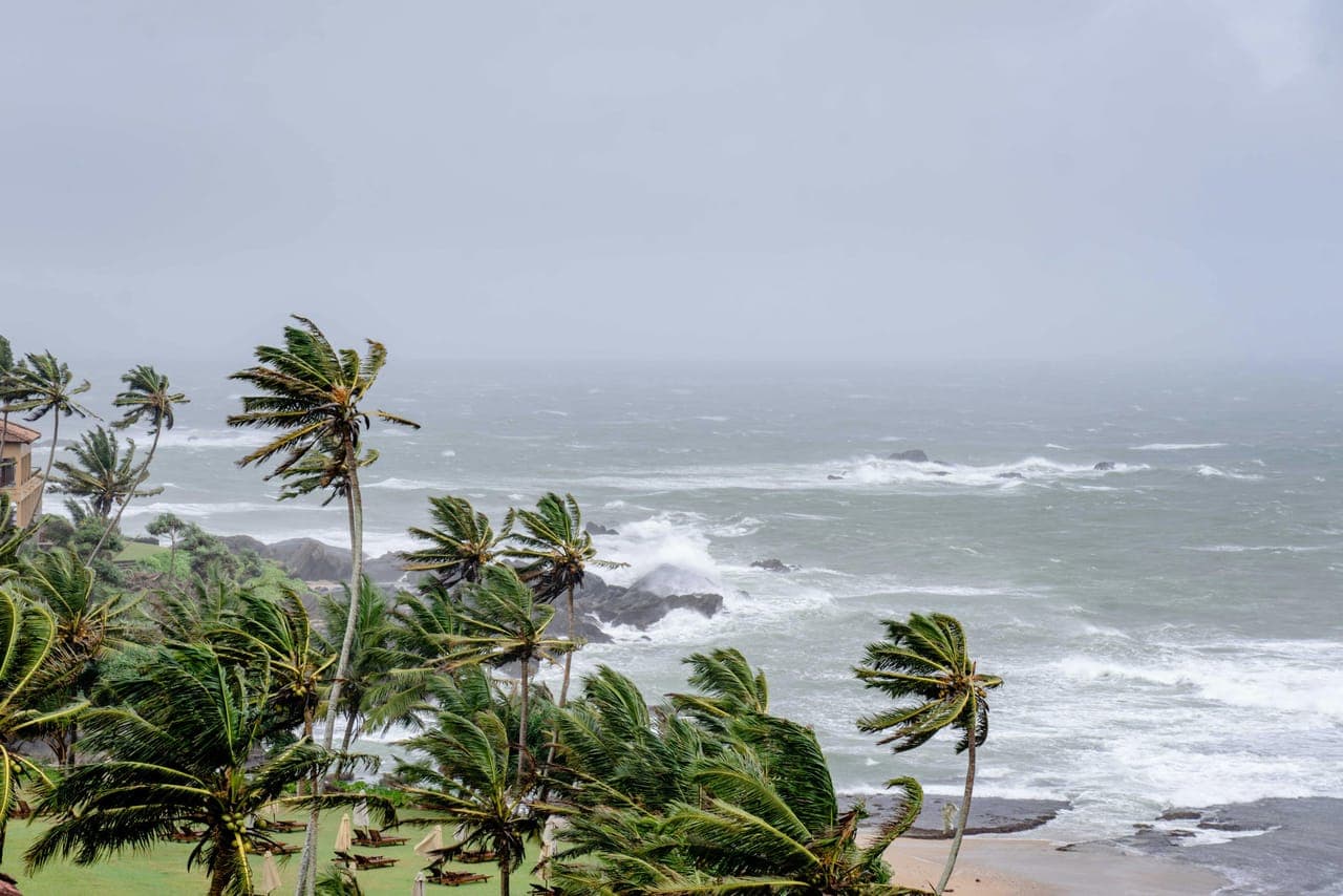 Coastal property against a stormy sky representing wind exposure